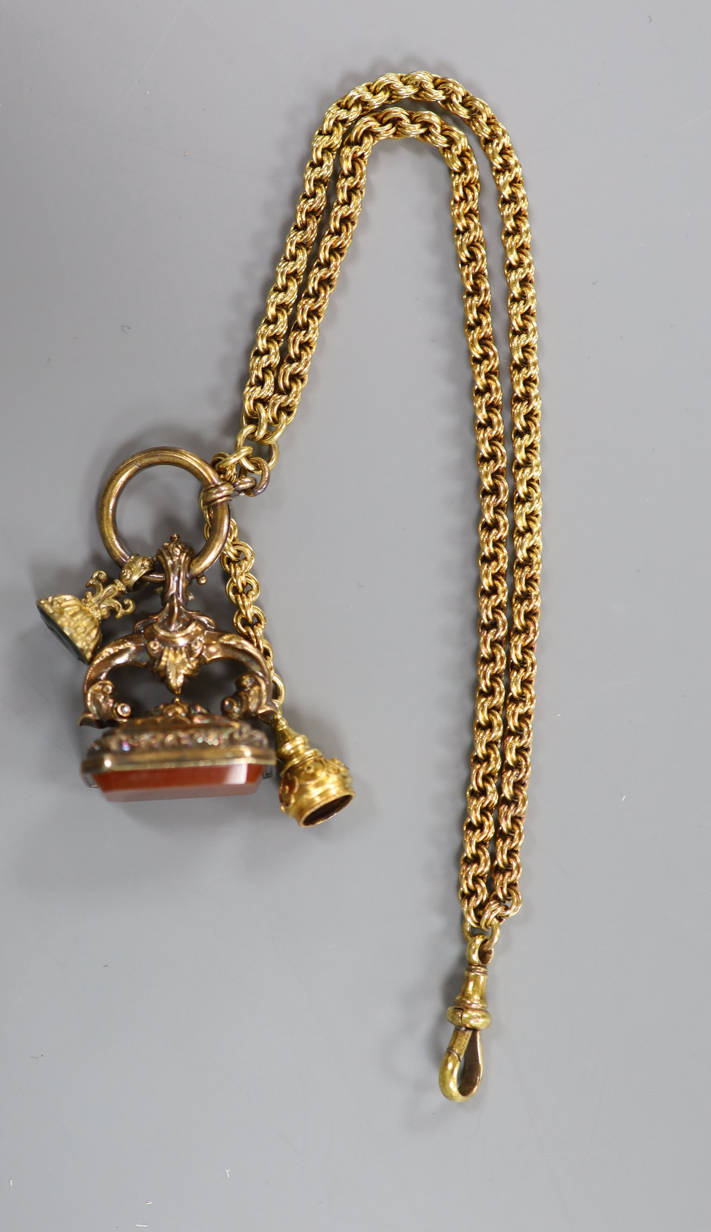 Two gilt metal and chalcedony set fob seals, (agate and bloodstone) and one other seal, all hung from a gilt metal chain.